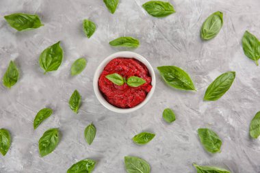 Kırmızı sos ve fesleğen gri arka plan üzerinde düz yatıyordu kompozisyonu