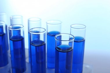 Test tüpleri renk arka plan üzerinde mavi sıvı ile
