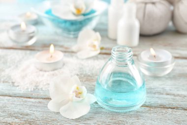 Uçucu yağ spa yordamlar ve ahşap masa üzerinde güzel çiçek şişe