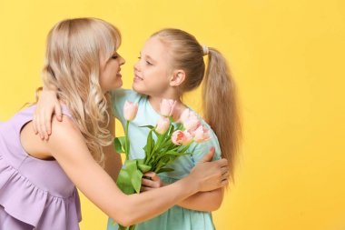 Sevimli küçük kız ve annesi Lale buketi renk arka plan üzerinde ile portre