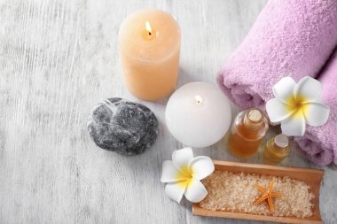 Rulo havlu, mumlar ve ahşap arka plan üzerinde deniz tuzu ile Spa kompozisyon