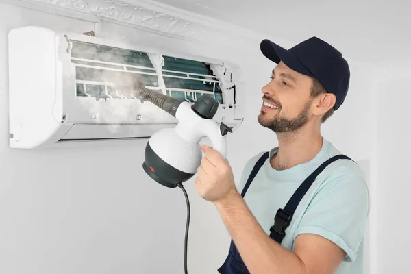 Technician cleaning air conditioner indoors — Stock Photo, Image