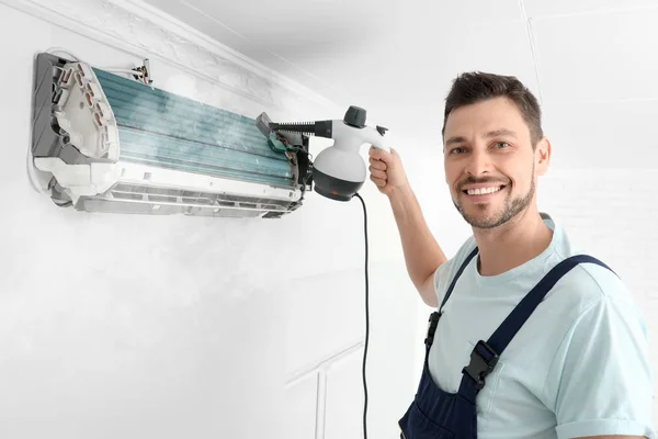Technician cleaning air conditioner indoors — Stock Photo, Image