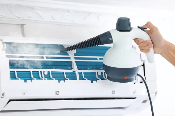 Technician cleaning air conditioner indoors — Stock Photo, Image