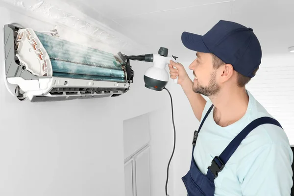 Technician cleaning air conditioner indoors — Stock Photo, Image