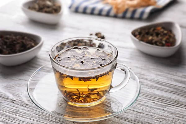 Glass cup with aromatic tea on table — Stock Photo, Image