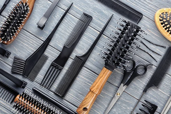 Composição de leigos plana com ferramentas de cabeleireiro profissional em fundo de madeira — Fotografia de Stock
