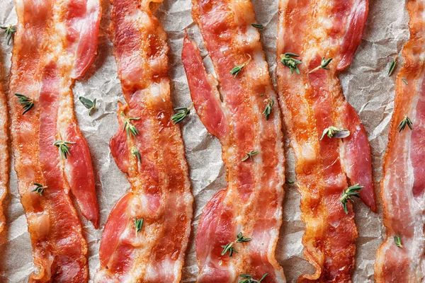 Pergament mit schmackhaftem gebratenem Speck, Nahaufnahme — Stockfoto