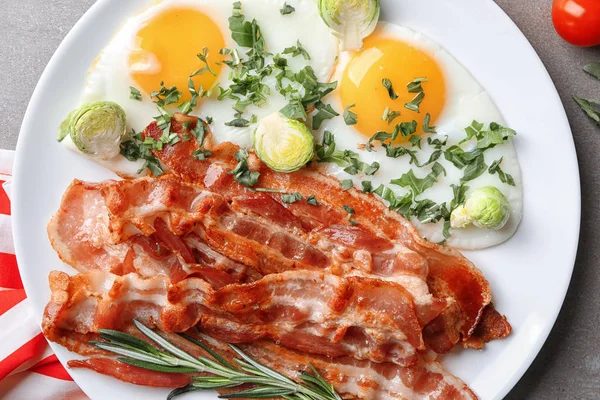 Deska s chutné slaninou a smaženými vejci na stůl — Stock fotografie