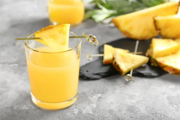 Glas zoete sap met ananas schijfje op tafel — Stockfoto
