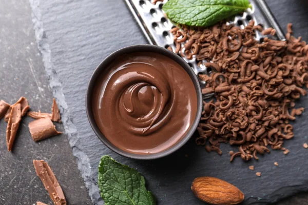 Tasty melted and grated chocolate on table — Stock Photo, Image