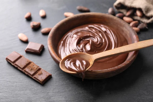 Kase ve kaşık masada lezzetli eritilmiş çikolata ile — Stok fotoğraf