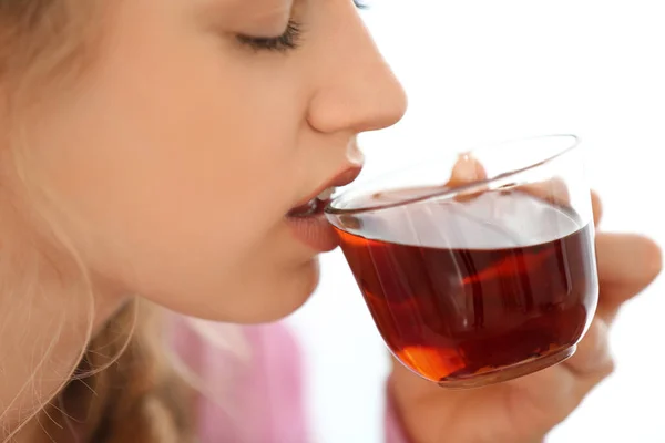 Jeune femme buvant du thé sur fond clair — Photo