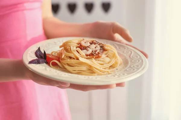 Mujer joven con plato de pasta sabrosa en casa, primer plano — Foto de Stock