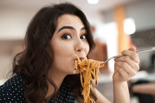 Mujer joven divertida comiendo pasta sabrosa en la cafetería —  Fotos de Stock