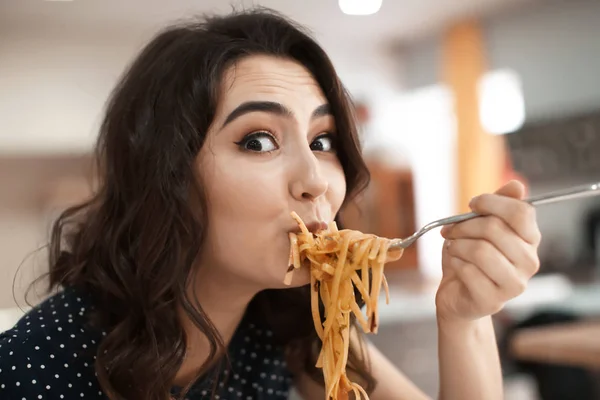 Mujer joven divertida comiendo pasta sabrosa en la cafetería — Foto de Stock