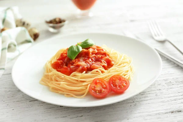 Talerz makaron z sosem pomidorowym na biały drewniany stół — Zdjęcie stockowe
