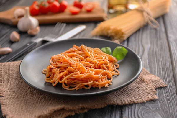 Plate of delicious pasta with tomato sauce on wooden table — Stock Photo, Image