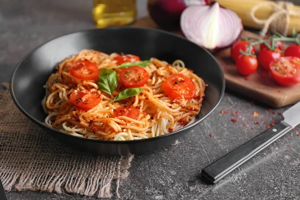 Plate of delicious pasta with tomatoes on table — Stock Photo, Image