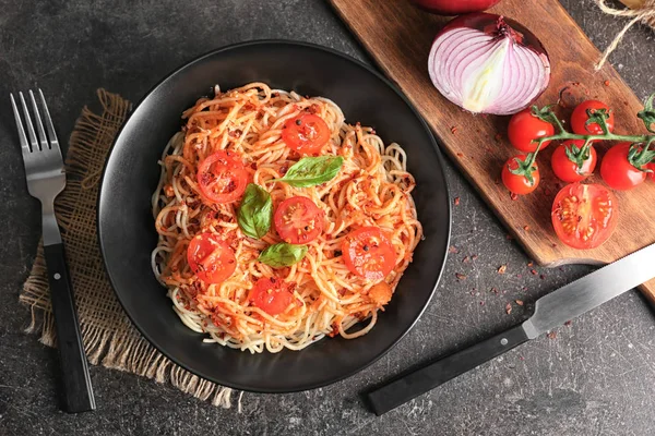 Placa de deliciosa pasta con tomates en la mesa — Foto de Stock