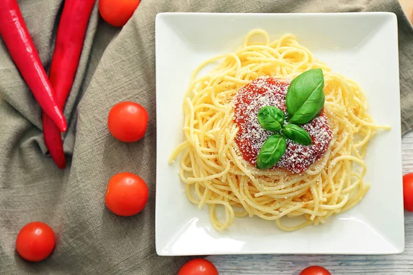 Talerz spaghetti i sosem na stole. Makaron przepisy kulinarne — Zdjęcie stockowe