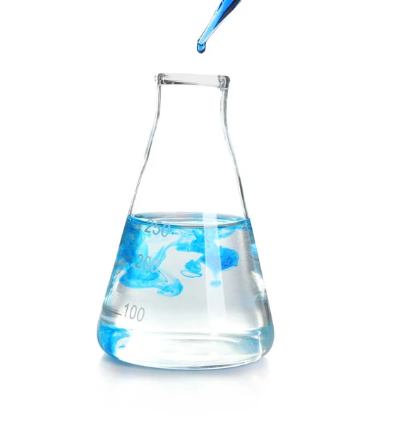 Goteo de líquido azul en cristalería de laboratorio sobre fondo blanco — Foto de Stock