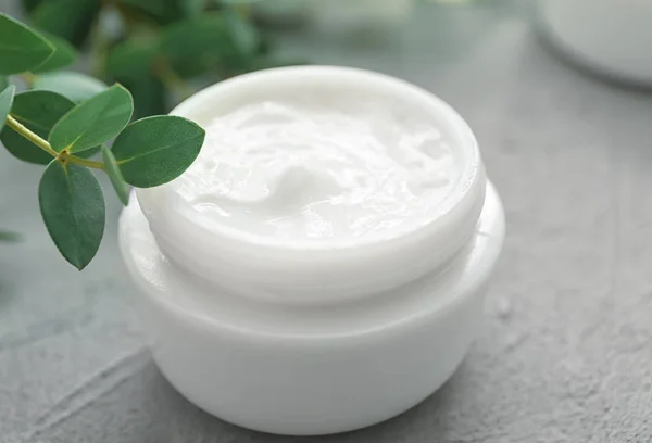 Jar of cream with herbal extract on grey background — Stock Photo, Image