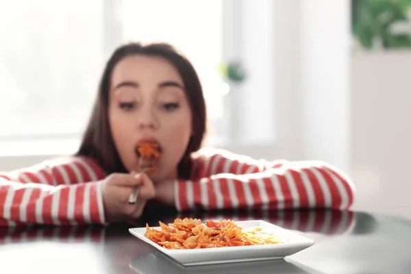 Mujer joven comiendo deliciosa pasta en la mesa, primer plano — Foto de Stock