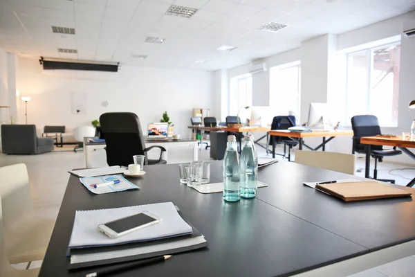 Interno ufficio con bottiglie d'acqua e documenti in tavola. Progettazione del posto di lavoro — Foto Stock