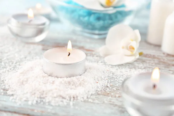 Burning candle and sea salt for spa on wooden table — Stock Photo, Image