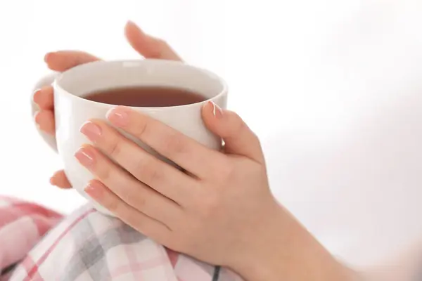 Young woman with cup of hot tea at home, closeup — Stock Photo, Image