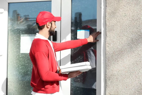 Entrega homem com caixas de pizza de papelão perto da casa do cliente ao ar livre — Fotografia de Stock