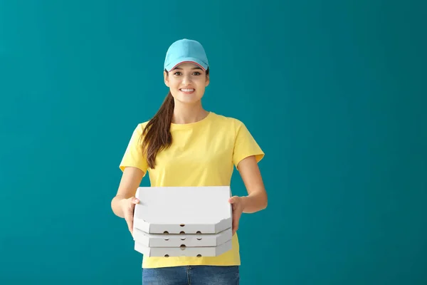 Delivery woman with cardboard pizza boxes on color background — Stock Photo, Image