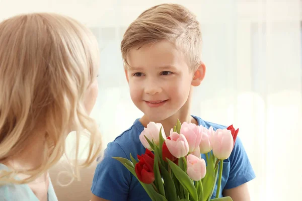 Ritratto di bambino carino e sua madre con bouquet di tulipani a casa — Foto Stock