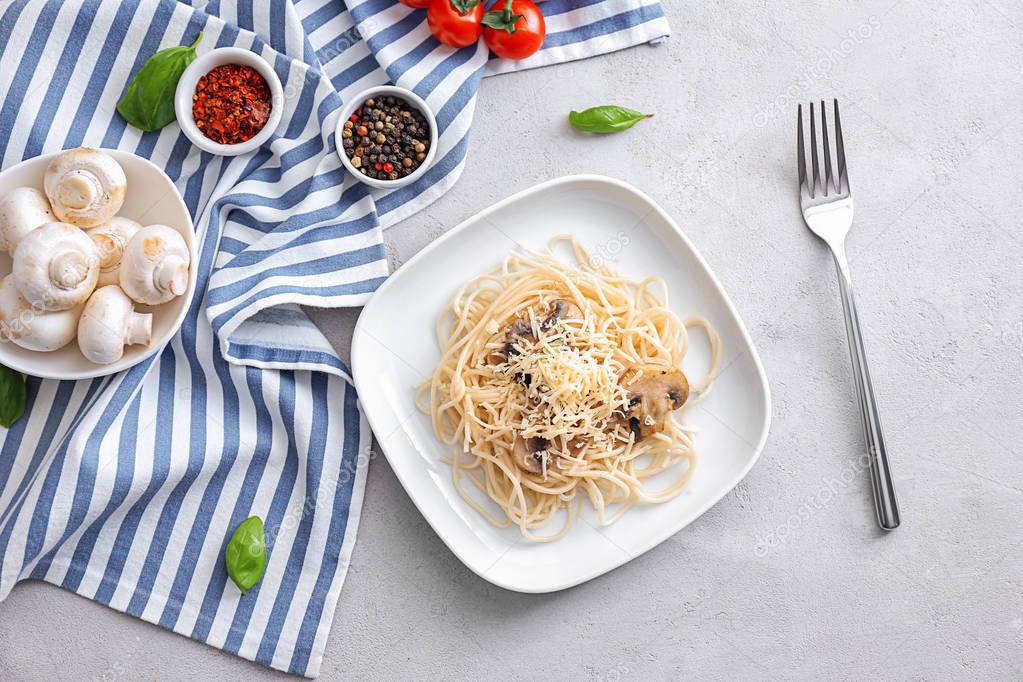 Plate of delicious pasta with cheese and mushrooms on table