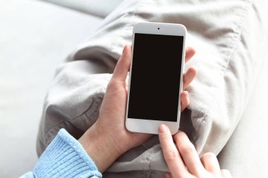 Kapalı alanda cep telefonu kullanan kadın.