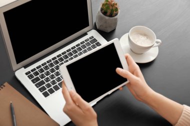 Tablet bilgisayar masasında kullanan genç kadın