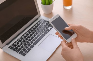 Masada akıllı telefon kullanan genç bir kadın.