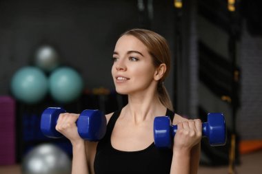 Modern bir spor salonu dumbbells ile eğitim genç kadın