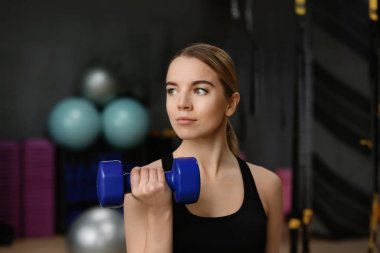 Genç kadın dumbbell modern spor salonu ile eğitim