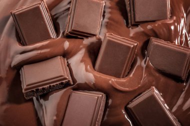 Tasty melted and solid chocolate, closeup clipart