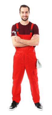 Beyaz arka plan üzerinde araçlarıyla genç araba tamircisi