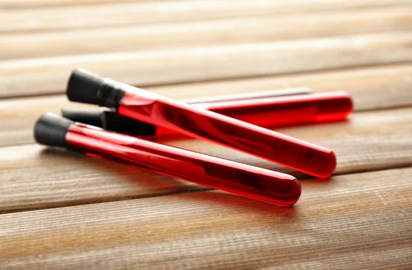 Test tubes with blood samples on wooden background — Stock Photo, Image