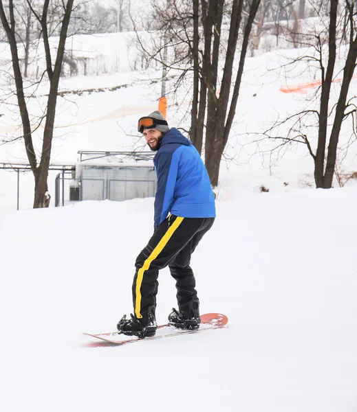 Male snowboarder on slope at winter resort — Stock Photo, Image