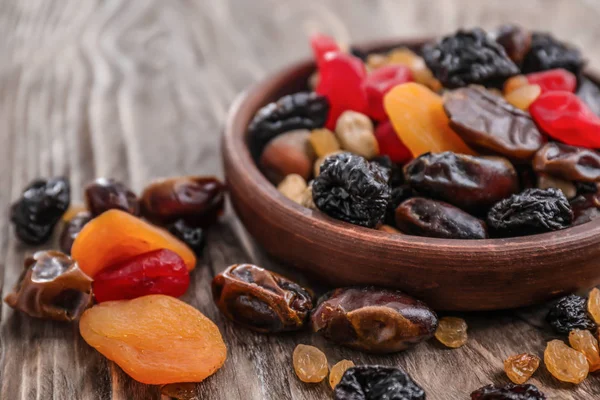 Plate with mix of dried fruits and berries on wooden background — Stock Photo, Image