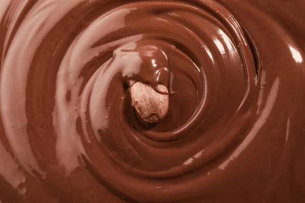 Grão de cacau em chocolate derretido, close-up — Fotografia de Stock