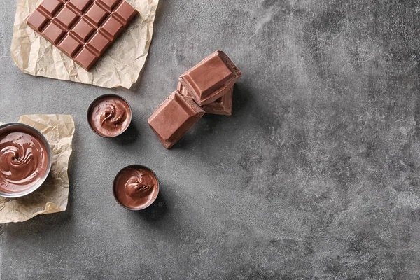 Composition avec délicieux chocolat fondu sur fond gris, vue sur le dessus — Photo