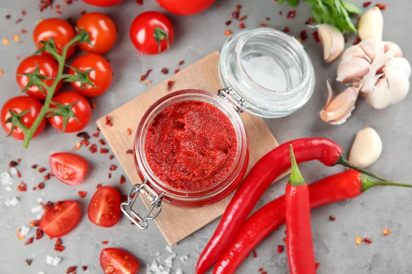 Glas mit roter Sauce und Gemüse auf dem Tisch — Stockfoto