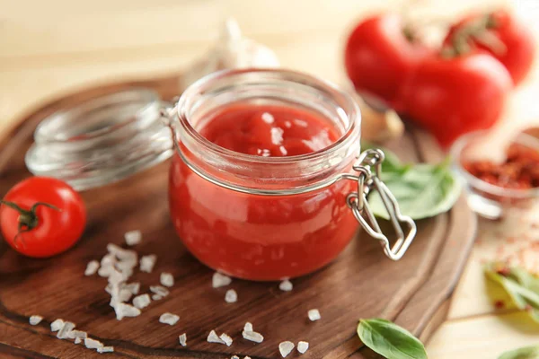 Köstliche rote Sauce im Glas und Zutaten auf dem Tisch — Stockfoto
