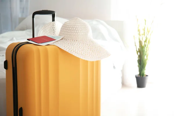 Large suitcase, hat and documents indoors — Stock Photo, Image